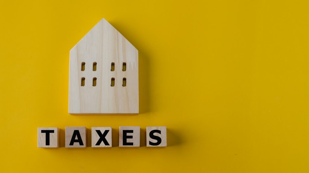 Property tax concept. investment planning.Wooden blocks with the word TAXES and a house