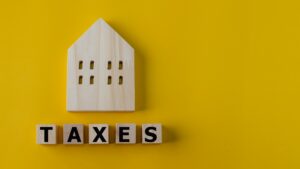 Property tax concept. investment planning.Wooden blocks with the word TAXES and a house