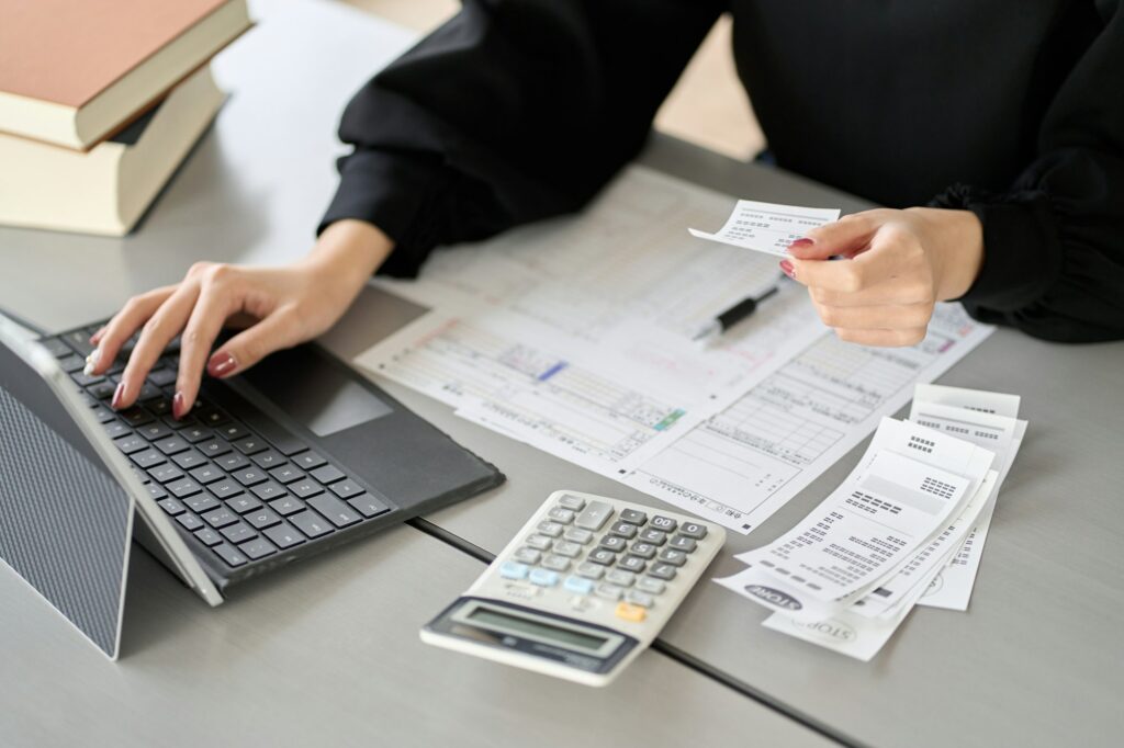 Asian woman entering expenses in accounting software